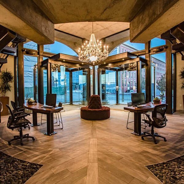 Hardware apartments entry lobby with elegant leasing desks, plush round couch, and large chandelier.