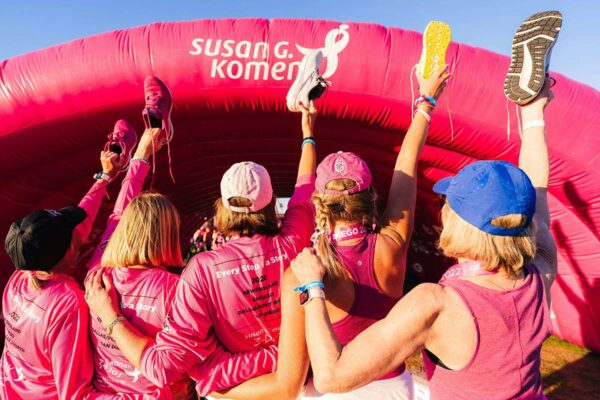 Friends dressed in pink participating in Susan G Komen breast cancer awareness event.