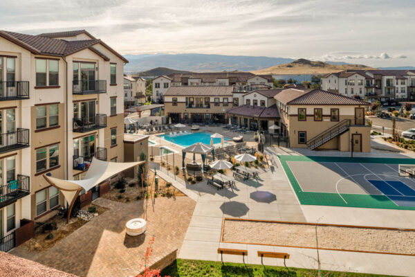 Double R pool area with lounge chairs, outdoor basketball court, and rocky landscaping.