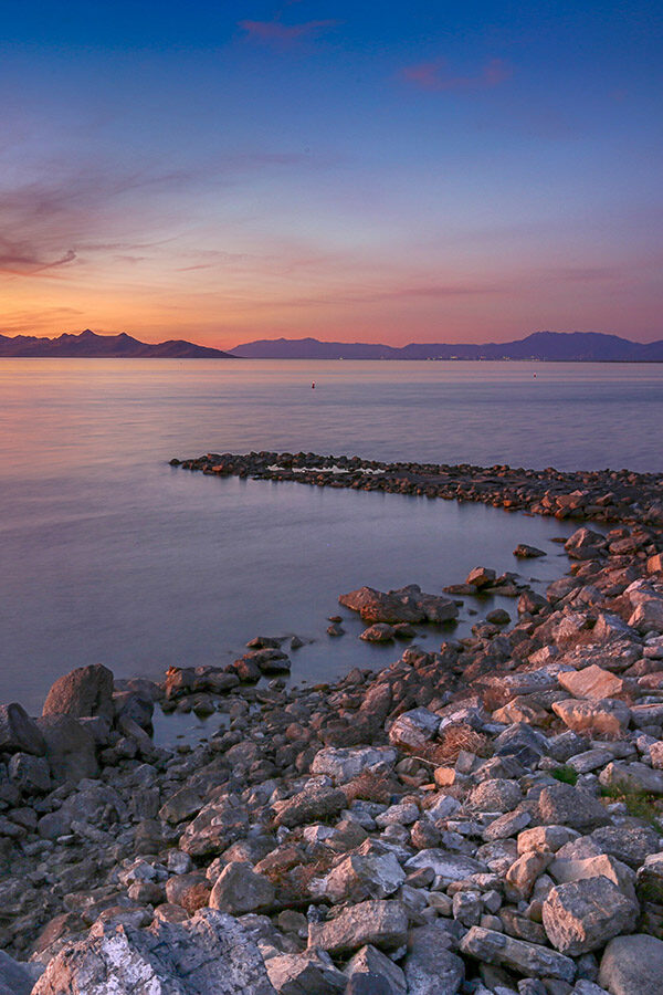 The Great Salt Lake in Utah under colorful sunrise skies.